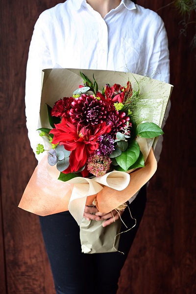 様々な赤系の花材と葉物でゴージャスに仕上げた花束　スタンダードタイプ